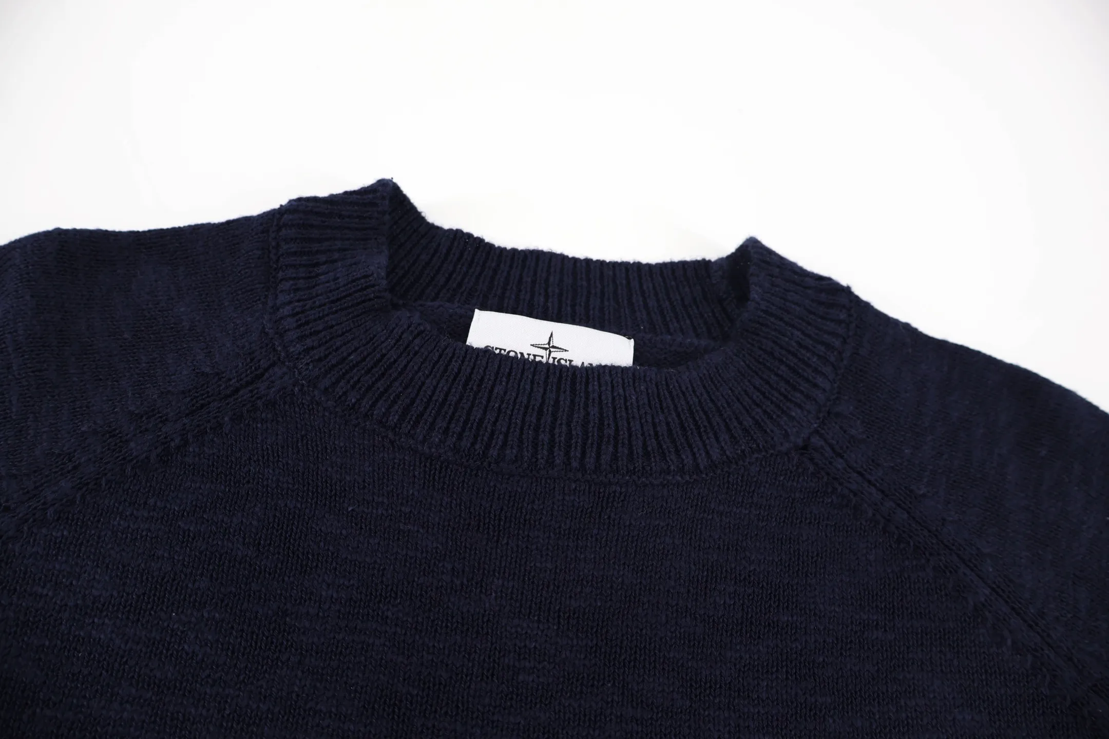 P460 Stone Island Stone Island embroidered sweater (blue). The original version was purchased and developed for 4,050 yuan. It is woven with yarn knitted from 58% wool and 42% nylon. The classic navy blue tone outlines a simple silhouette, and the raglan sleeve design takes into account both wearing comfort and the beauty of the shoulder line. The white embroidered brand logo and starburst pattern on the chest form a visual highlight, and the delicate stitching shows the craftsmanship. The selected knitted fabric is soft and skin-friendly, and the ribbed collar, cuffs and hem enhance the stiffness of the silhouette. Whether worn alone or layered, you can easily create a daily look that combines functionality and style. Size:S-M-L